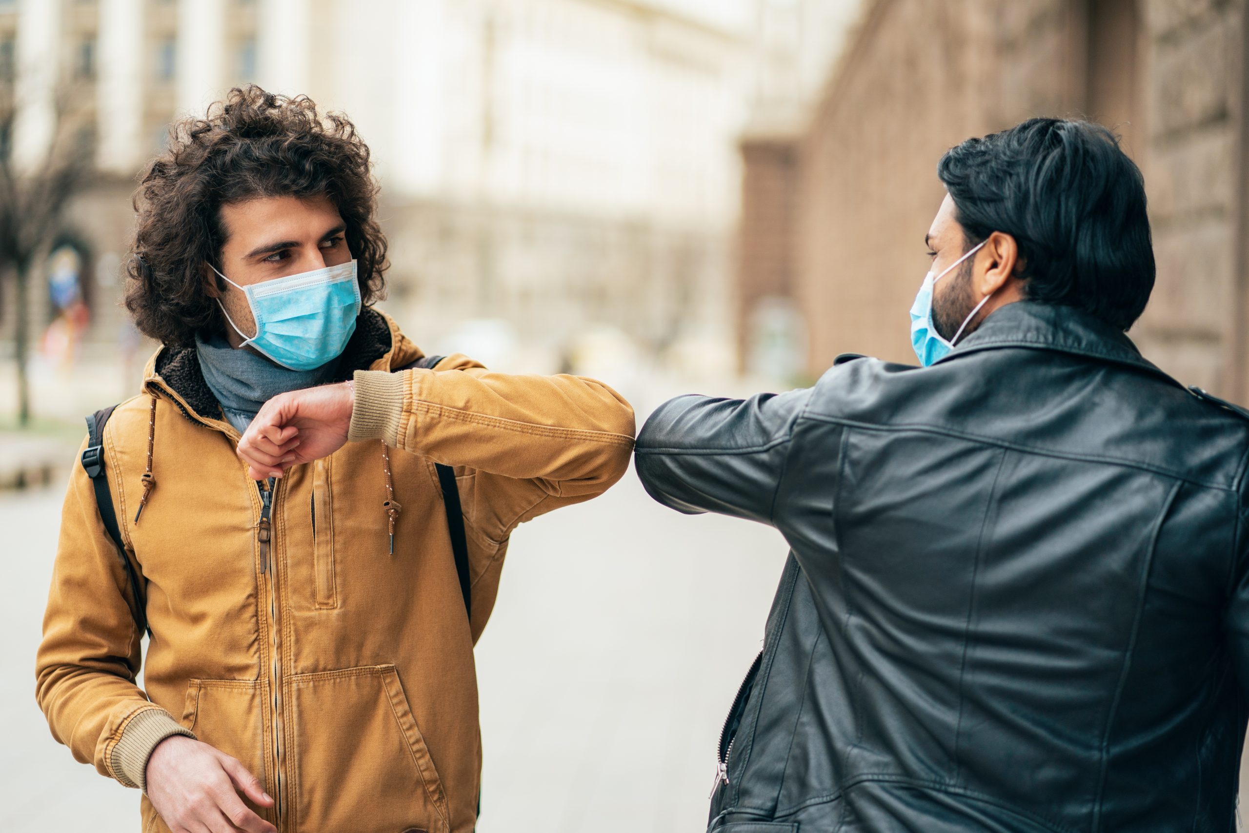 Young people friends meeting in quarantine and greeting without touching their hands.